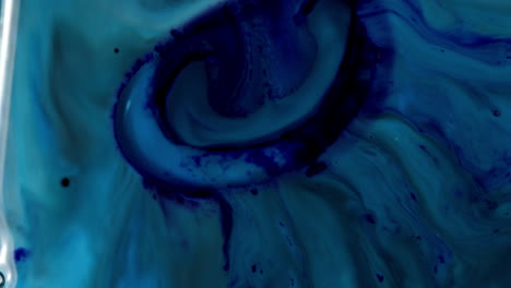 Oil-slick-dark-blue-pattern-blob-absorbs-in-green-ink-water