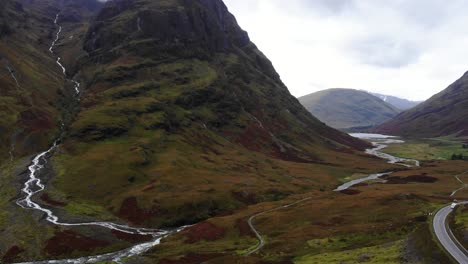 Vista-Aérea-Del-Espectacular-Paisaje-De-Glencoe-En-Escocia-Con-El-Río-Coe-Fluyendo-En-El-Medio