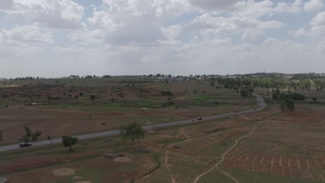 Aerial-forward-drone-shot-over-cars-on-rural-road-in-sub-saharan-Africa