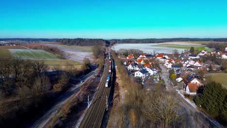 Winter-Bahn-Pendeln-Neben-Einem-Verschlafenen-Dorf