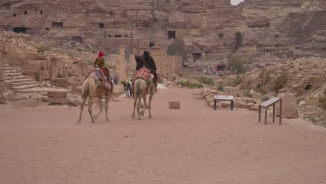 Beduinen-Reiten-Auf-Kamelen-Zum-Römischen-Theater-In-Petra,-Jordanien,-Archäologische-Stätte