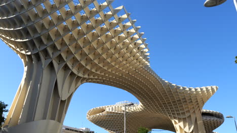 Tilt-down-shot-of-Metropol-Parasol-structure,-people-around,-Seville,-Spain