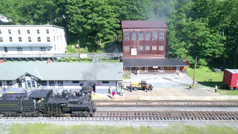 Luftaufnahme-Einer-Antiken-Shay-Dampflokomotive,-Die-An-Einem-Sonnigen-Sommermorgen-Langsam-Rückwärts-Fährt,-Um-Sich-Einem-Bahnhof-Zu-Nähern