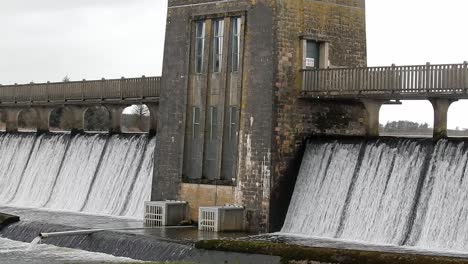 Llyn-Cefni-reservoir-concrete-generator-gate-overflowing-from-Llangefni-lagoon-in-Anglesey,-North-Wales