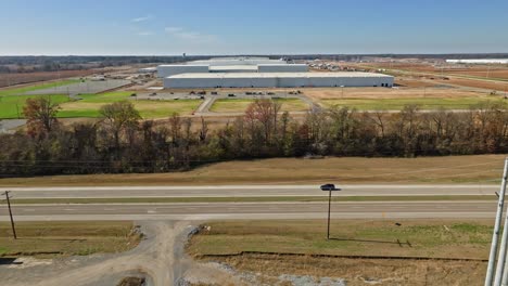 Vehículo-Que-Sigue-Desde-El-Aire-Pasando-Por-La-Ciudad-Blueoval-De-Ford,-Mostrando-El-Progreso-De-La-Construcción-De-Las-Instalaciones-En-El-Fondo.