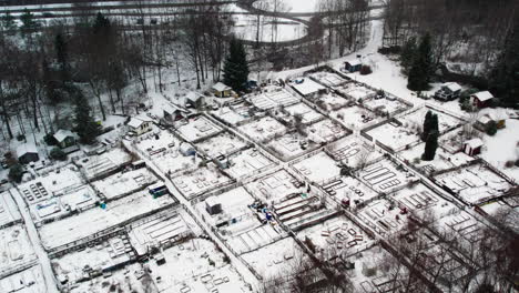 Snow-covered-community-gardens-in-kortedala,-gothenburg-during-winter,-aerial-view
