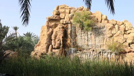 Oasis-waterfall-with-lush-greenery-in-Sbeitla,-Tunis,-under-a-clear-blue-sky