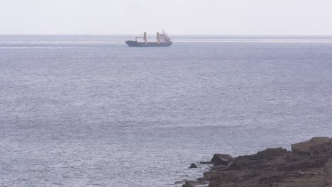 cargo-ship-moored-near-the-coast-on-a-calm-day