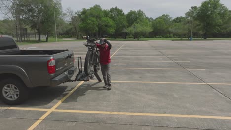 A-senior-male-loads-an-electric-e-bike-onto-a-hitch-mounted-bike-rack-with-a-ramp-in-Pasadena,-Texas