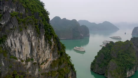 Vista-Aérea-De-Barcos-Turísticos-Navegando-Por-La-Pintoresca-Bahía-De-Halong,-Vietnam