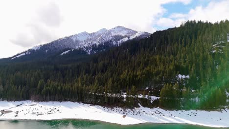 Toma-Delantera-Del-Lago-Kachess-Con-Banco-De-Nieve-Y-Bosque-Siempre-Verde-Con-Montañas-Nevadas