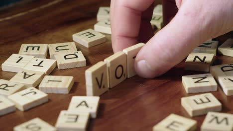 Primer-Plano-De-Enfoque-Estrecho:-Los-Mosaicos-De-Letras-De-Scrabble-Forman-Voto-De-Palabra-En-El-Juego