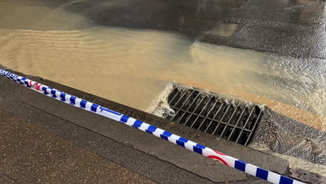 Una-Vista-De-Cerca-Del-Drenaje-De-Aguas-Pluviales-Revela-El-Caos-En-Las-Calles-De-Brisbane-Después-De-La-Explosión-Masiva-De-Una-Tubería-De-Agua-Subterránea,-Lo-Que-Provocó-Grandes-Interrupciones-En-El-Transporte-Público-Y-Problemas-De-Seguridad.