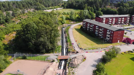 Heating-pipelines-in-a-trench-in-a-residential-area-during-the-day,-aerial-view