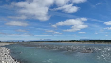 Gently-flowing-turquoise-colored-river-in-vast-summertime-landscape