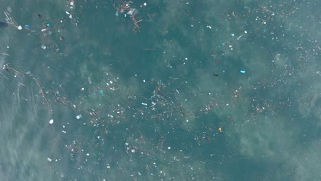 Un-Dron-Descendente-De-Arriba-Hacia-Abajo-Disparó-Sobre-Agua-Contaminada-Llena-De-Basura-Plástica-En-Las-Aguas-Tropicales-Turquesas-De-La-Playa-De-Balangan-Uluwatu-Bali-Indonesia