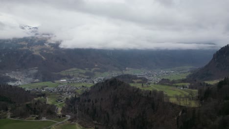 Establecimiento-Aéreo-De-La-Idílica-Ciudad-Rural-Del-Campo-Europeo-En-La-Base-De-Montañas-Cubiertas-Por-Nubes