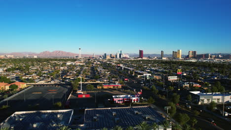 Las-Vegas-Nevada-Cityscape-Skyline,-Drone-Shot,-Evening-Traffic-in-Neighborhood-by-Strip-Hotels-and-Casinos