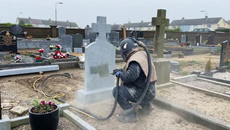 sandblasting-headstone-grave-marker-in-cemetry-man-working