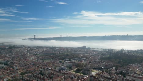 Tranquilidad-Brumosa:-Toma-Estática-Que-Revela-La-Atmósfera-Mística-Debajo-Del-Puente-De-Lisboa,-Con-Una-Dispersión-De-Nubes-En-El-Cielo