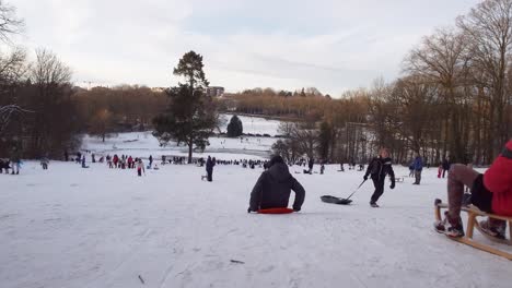 Gente-Disfrutando-De-Trineos-De-Nieve-En-El-Parque-Woluwe-En-Woluwe-saint-pierre,-Bélgica