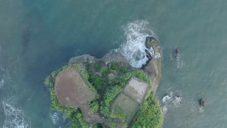 Top-down-drone-shot-over-tropical-Balangan-Beach-peninsula-in-Uluwatu-Bali-Indonesia-with-crashing-waves-and-turquoise-water