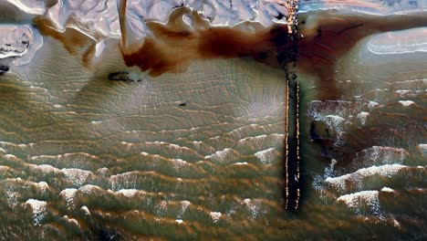 Baltic-Sea-shipwreck-with-old-pier-in-water-with-a-brownish-tint,-due-to-natural-stream-pollution