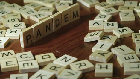 Das-Wort-„Pandemie“-Besteht-Aus-Scrabble-Buchstabensteinen-Auf-Einer-Holztischplatte