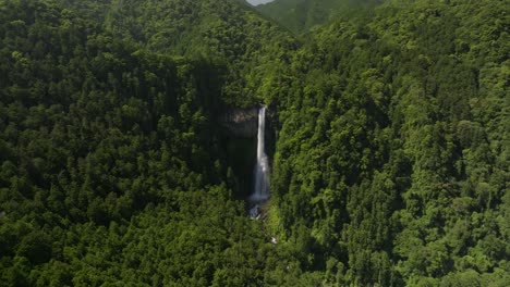 Slow-tilt-reveal-shot-from-distance-of-Nachi-waterfall,-the-biggest-in-Japan