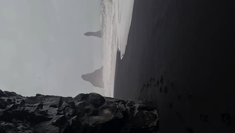 Vídeo-Vertical,-Playa-De-Arena-Negra-Y-Pintoresca-Costa-De-Islandia-En-Un-Día-Oscuro-Y-Lluvioso