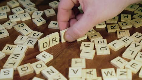 Five-letter-game-tiles-on-wooden-table-top-form-the-word-DRUGS
