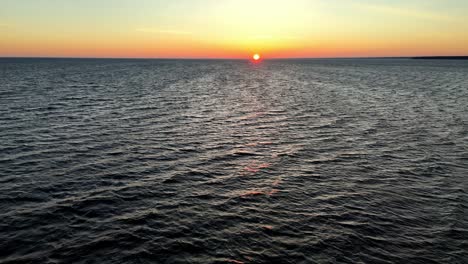 Farbenfroher-Sonnenuntergang-über-Einem-Riesigen-Ozean,-Mit-Einem-Kleinen-Boot,-Das-Sich-Gegen-Den-Lebhaften-Himmel-Abhebt.-Atlantik-Bei-Sonnenuntergang,-Möglicherweise-In-Der-Nähe-Der-Küste-Von-New-Jersey,-Delaware,-In-Den-Vereinigten-Staaten