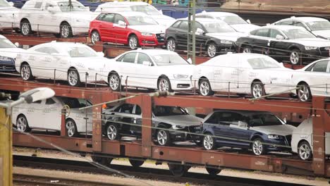 Neue-Audis-Auf-Einem-Güterzug,-Bereit-Zur-Auslieferung,-Industrieller-Hintergrund
