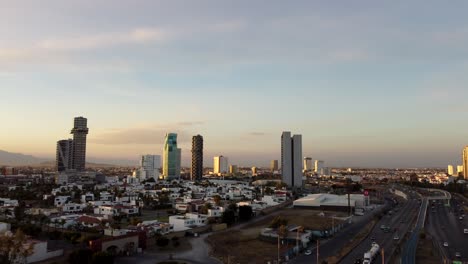 Aerial-approaching-flight-showing-downtown-of-Puebla-City-with-high-rise-Buildings-at-golden-hour
