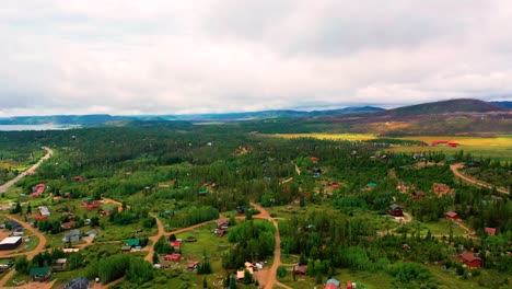 Aerial-Drone-View-of-Colorado-Mountain-Town-Surrounded-by-Rolling-Hills-and-Lush-Summer-Forests-in-the-Rocky-Mountains-at-a-High-Elevation