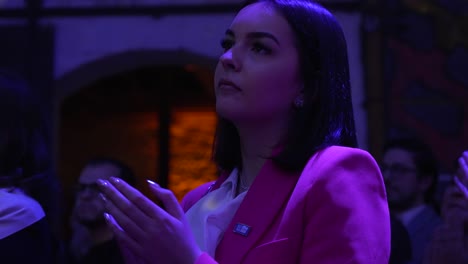 Mujer-Con-Blazer-Rosa-Aplaudiendo-En-El-Evento