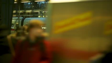 Blurred-travelers-at-Frankfurt-train-station,-evening-rush,-warm-tones