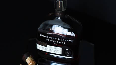 Botella-De-Whisky-Bourbon-Kentucky-De-Doble-Roble-De-90-Grados-De-Reserva-Woodford-Descorchado-Con-Un-Corcho-Húmedo-Sentado-Sobre-Un-Reflejo-De-Espejo