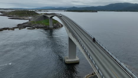 Atlantic-Road-Bridge-with-bike-rider-and-traffic-passing,-Norway