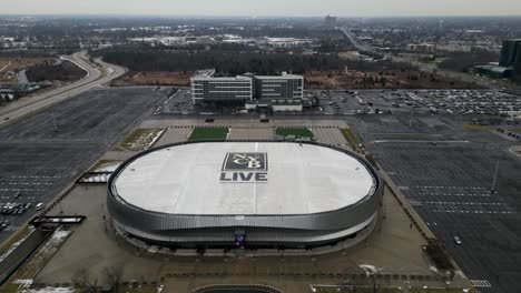 Aerial-Pull-away-drone-footage-of-Nassau-Coliseum-in-Uniondale,-showing-the-NYCB-LIVE-logo-on-the-roof