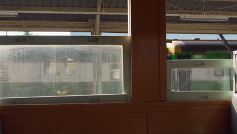 The-view-from-inside-the-train-through-the-train-window-shows-the-train-approaching-the-station-to-pick-up-passengers-at-Hua-Lamphong-Station,-Bangkok