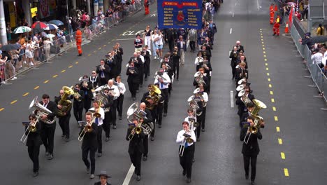 During-Anzac-Day-commemorations,-veterans,-their-families,-and-marching-band-walking-down-Adelaide-street,-honouring-the-memory-of-those-who-served,-Brisbane-city