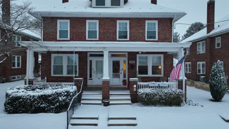 American-Flag-in-front-of-noble-American-House-in-Winter-Snow