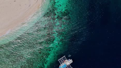 Von-Oben-Aufgenommene-Drohnenaufnahmen-Eines-Bootes-Im-Tiefblauen-Wasser-Auf-Den-Philippinen