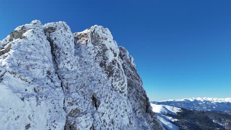 Snowy-Coltii-Strungii-Peak-under-clear-blue-sky,-Bucegi-Mountains,-daylight