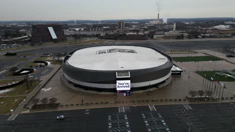 Aerial-Orbiting-drone-footage-of-Nassau-Coliseum-in-Uniondale,-showing-the-NYCB-LIVE-logo-on-the-roof