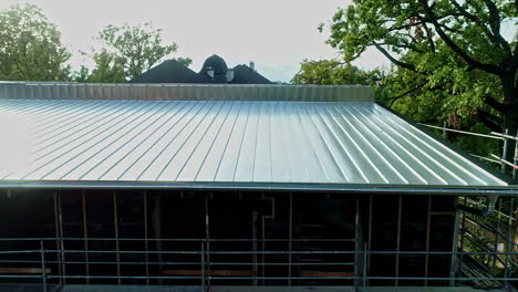 New-build-stainless-steel-house-roof-slow-aerial-presentation