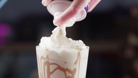 Spraying-whipped-cream-over-a-chocolate-milkshake