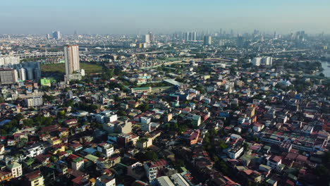 Aerial-tracking-shot-overlooking-cityscape-in-the-San-Andres-Bukid-in-Manila,-Philippines