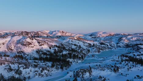 Snow-Blanket-Forest-Mountain-Ridge-At-Sunset-Near-Bessaker,-Norway